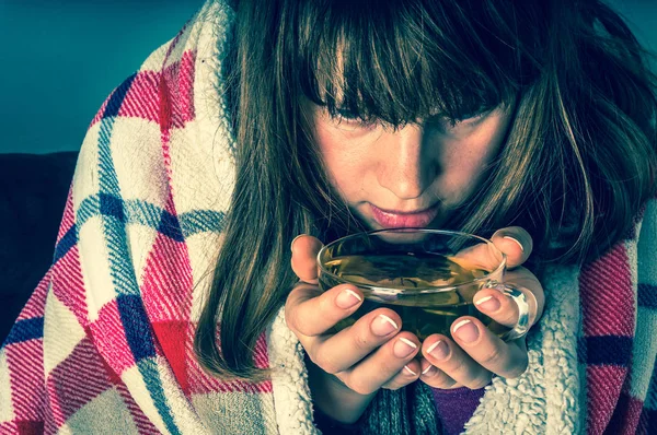 Mujer joven enferma con fiebre bebiendo taza de té caliente — Foto de Stock