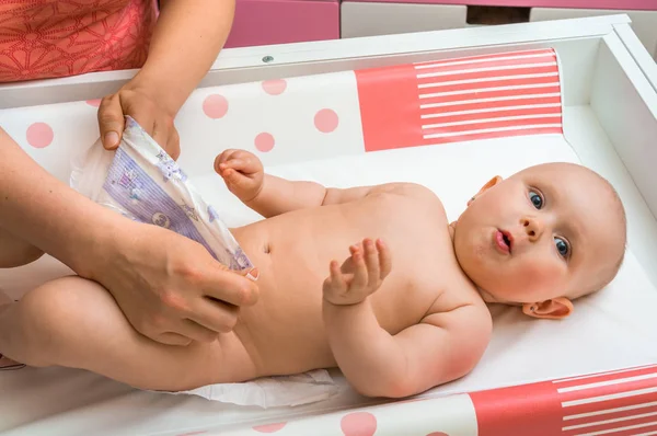 Mãe mudando fralda para sua filhinha — Fotografia de Stock