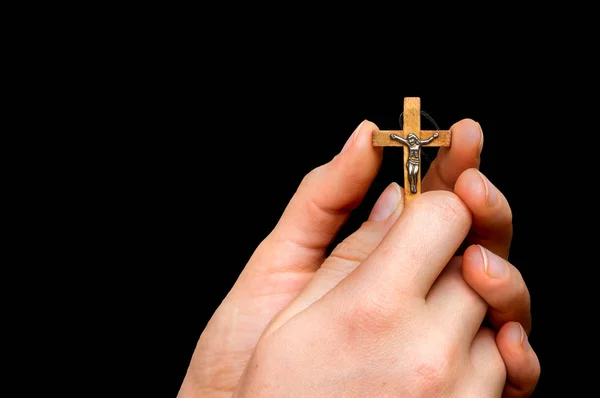 Mulher mãos segurando cruz de madeira isolado no preto — Fotografia de Stock