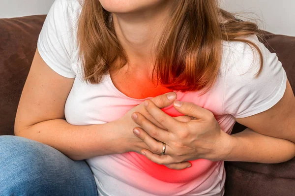 Mujer en sofá teniendo un ataque al corazón —  Fotos de Stock