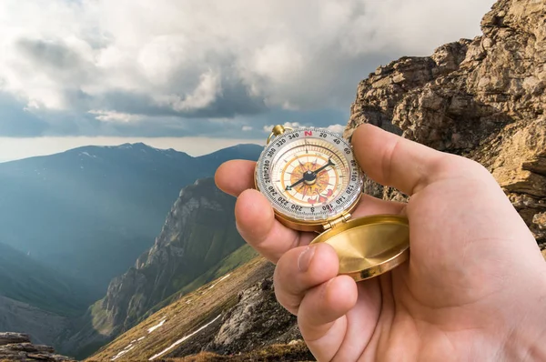 Traveler man with compass seeking a right way in the mountains — Stock Photo, Image