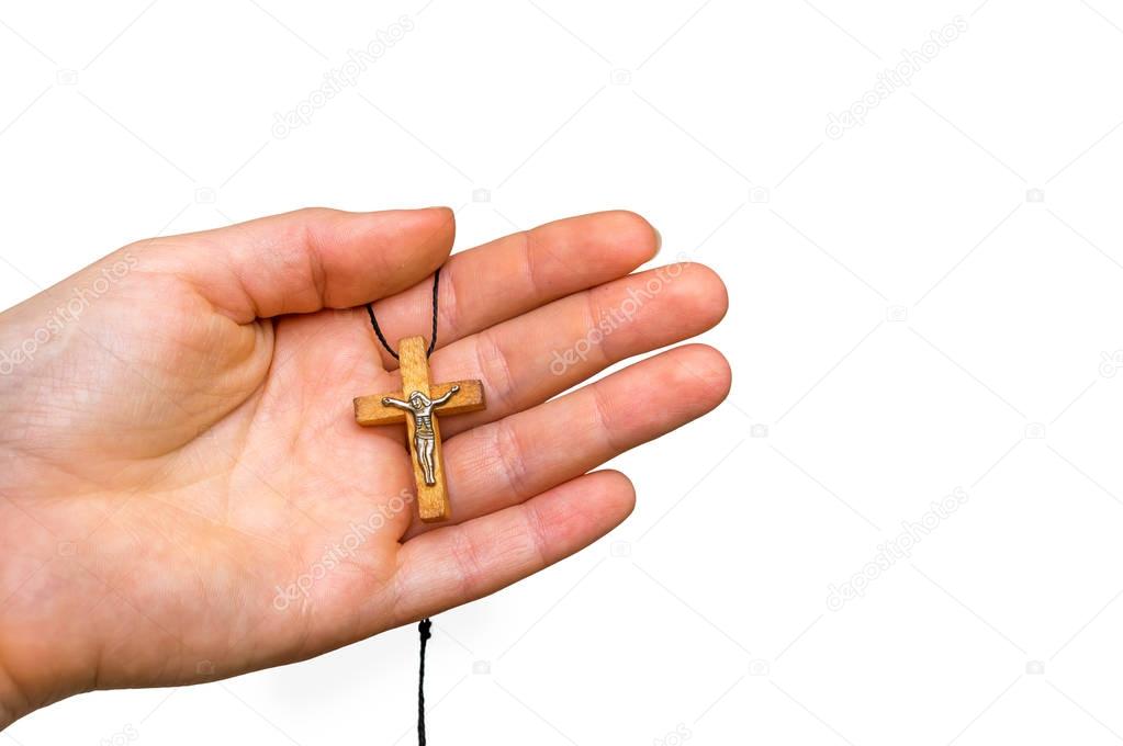 Wooden cross in female hand isolated on white