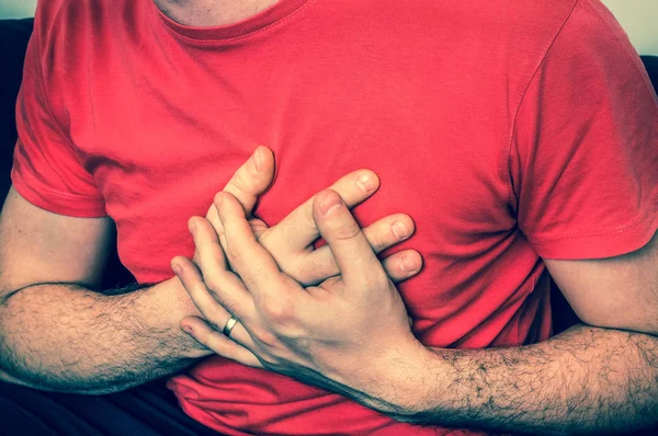Homem no sofá com dor no peito, ataque cardíaco — Fotografia de Stock
