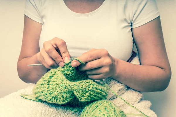 Mani donna con ferri a maglia con lana verde — Foto Stock