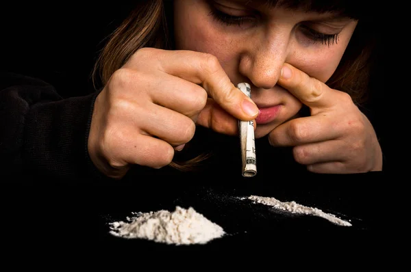Mujer drogadicta inhalando cocaína en polvo con billete enrollado — Foto de Stock