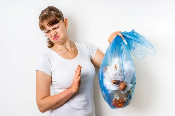 Mujer sosteniendo una bolsa de basura maloliente —  Fotos de Stock