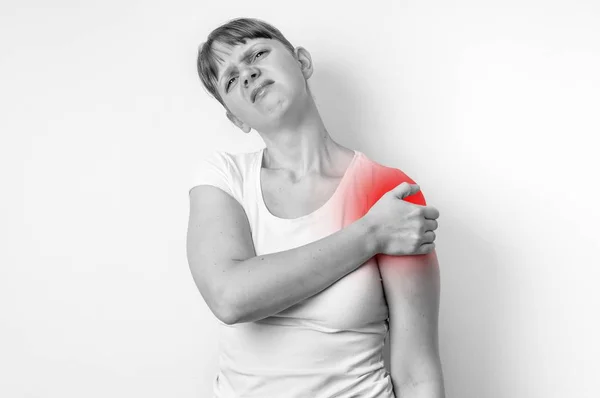 Vrouw met pijn in de schouder houdt haar pijnlijke arm — Stockfoto