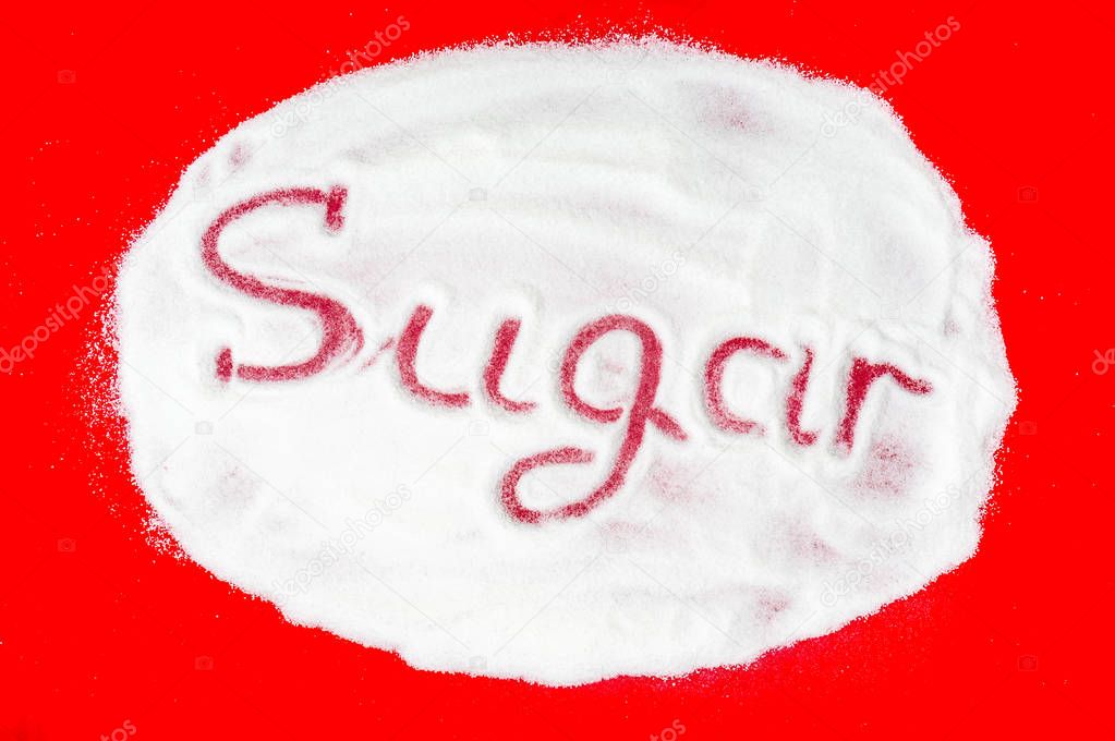 Word sugar written into a pile of white granulated sugar