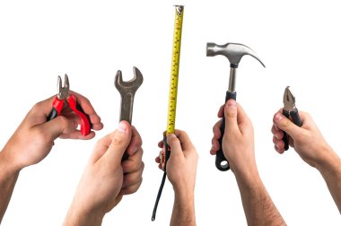 İngiliz anahtarı, pense, mezura ve işçilerin elinde çekiç