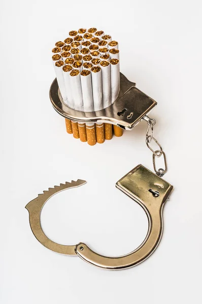 Сигареты и наручники - концепция зависимости от курения — стоковое фото