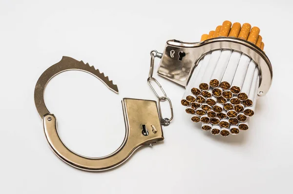 Cigarettes and handcuffs - smoking addiction concept — Stock Photo, Image