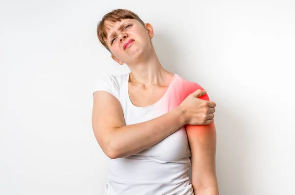 Mujer con dolor en el hombro sostiene su brazo dolorido —  Fotos de Stock