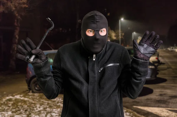 Maskierter Dieb mit Sturmhaube mit Brecheisen und erhobenen Armen festgenommen — Stockfoto