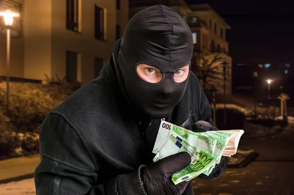 Maskerad tjuv i balaclava med stulna pengar — Stockfoto