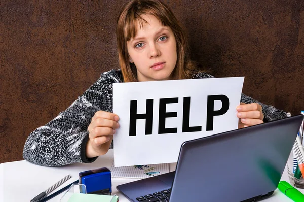 Vrouw die op haar laptop werkt en houden help teken — Stockfoto