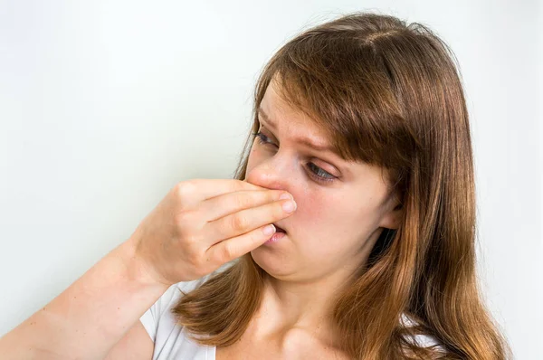 Mujer sosteniendo su nariz - concepto de mal olor — Foto de Stock