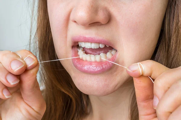 Kobieta, czyszczenie zębów z nici dentystyczne — Zdjęcie stockowe