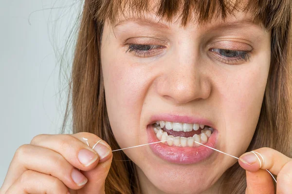 Kvinna tandtråd tänder med tandtråd — Stockfoto