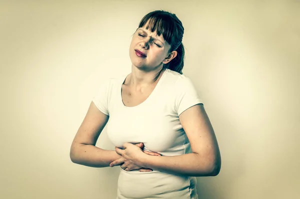 Жінка з болем у животі тримає її болить живіт — стокове фото