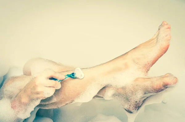 Женщина бреет ноги бритвой в ванной комнате - ретро стиль — стоковое фото
