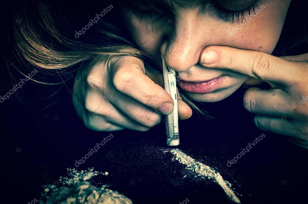 Femme de junkie renifler de la cocaine en poudre avec le billet