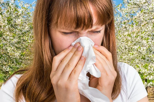 Mulher com alergia perto de árvores floridas — Fotografia de Stock