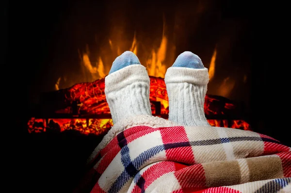 Nő felmelegedés méter a kandalló mellett gyapjú zokni — Stock Fotó