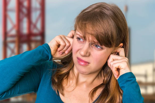 Kvinde dækker hendes ører for at beskytte mod høj støj - Stock-foto