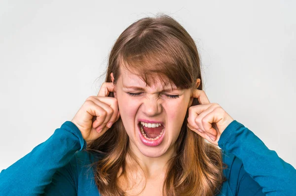 La mujer cierra los oídos con los dedos para protegerse del ruido fuerte — Foto de Stock