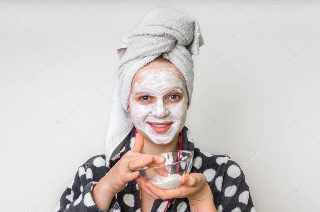 Woman applying natural facial mask from sour cream
