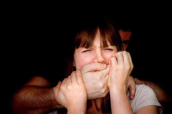 Мужчина прикрывает рот женщины, чтобы она не могла кричать — стоковое фото