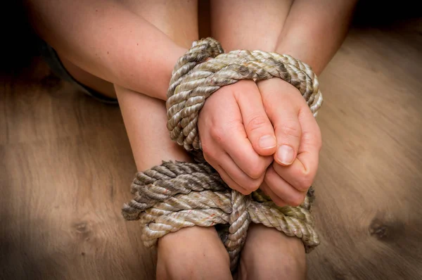 Викрадена жінка пов'язана з мотузкою на дерев'яній підлозі — стокове фото