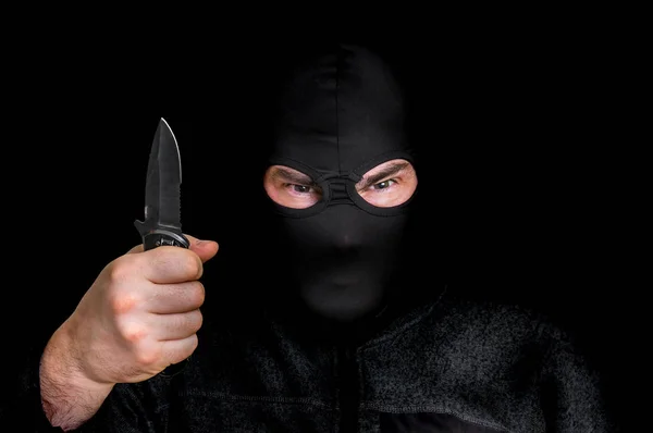 Мужчина в маске в балаклаве с ножом изолирован на черном — стоковое фото