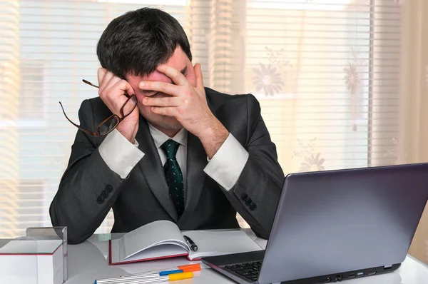 Homem triste trabalhando em laptop no escritório — Fotografia de Stock