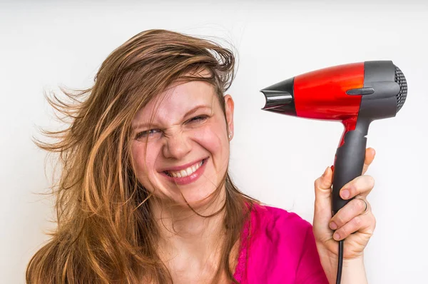 Hermosa mujer joven seca el cabello con secador de pelo — Foto de Stock