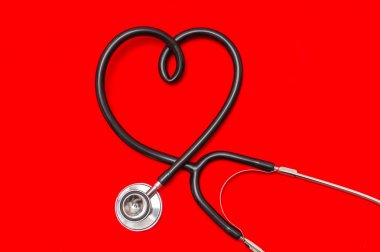 Kırmızı zemin üzerine izole kalp şeklinde stetoskop