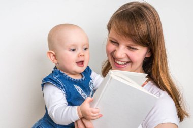 Gülümseyen anne ve çocuğunu bir kitap okuma
