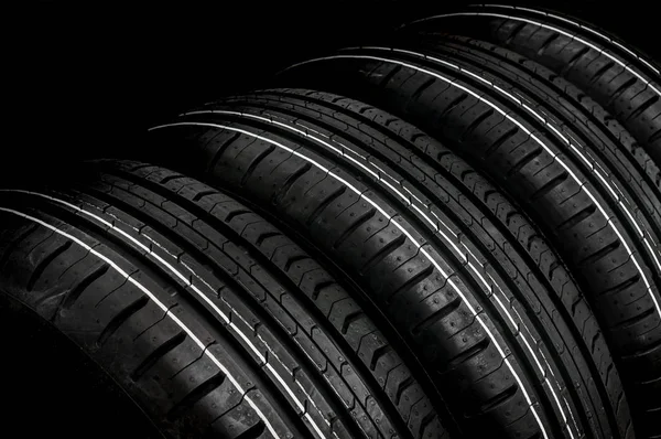 Neumáticos de coches en fila aislados en negro —  Fotos de Stock