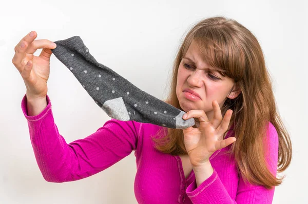 Mulher segurando meias fedorentas sujas — Fotografia de Stock