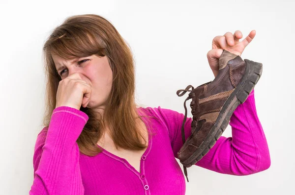Mujer sosteniendo sucios zapatos apestosos — Foto de Stock