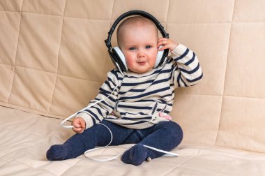 Kulaklıklar ile şirin bebek evde müzik dinliyor