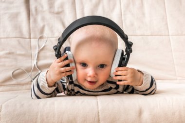 Kulaklıklar ile şirin bebek evde müzik dinliyor