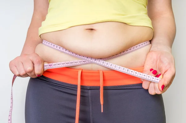 胖女人用胶带测量腹部脂肪 — 图库照片