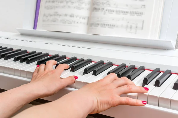 Nahaufnahme der Hände einer jungen Frau, die Klavier spielt — Stockfoto