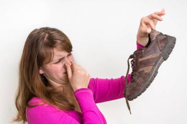 Woman with stinky shoe of her husband clipart