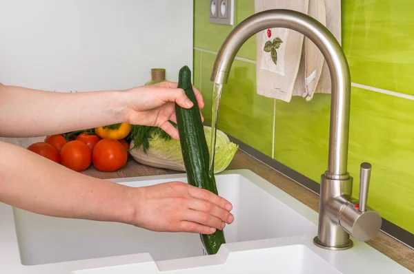 Woman washing cucumber for salad - fresh vegetables — Stock Photo, Image