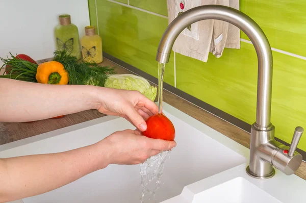 Woman washing tomato for salad - fresh vegetables — Stock Photo, Image