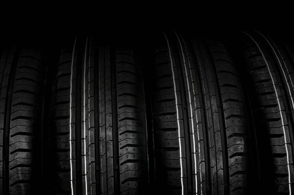 Car tires in row isolated on black — Stock Photo, Image