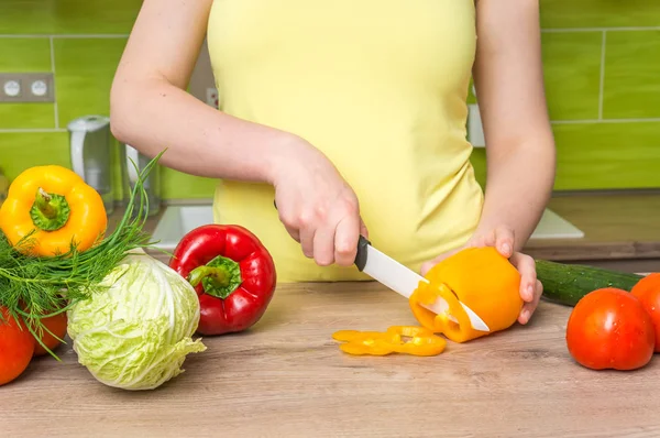 Woman cutting peppers for salad - fresh vegetables concept Stock Image