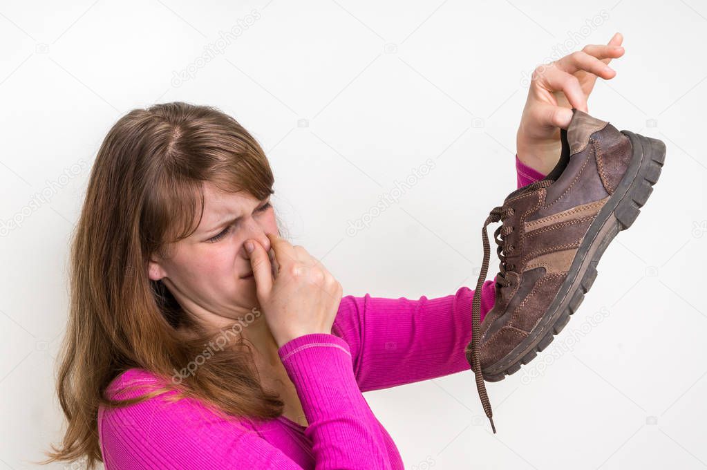 Woman with stinky shoe of her husband